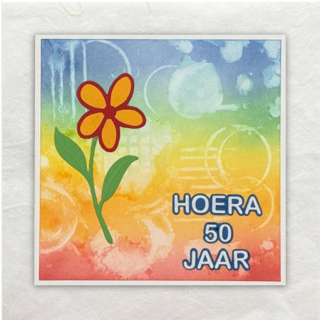 Achtergrond in Distress Oxide gesjabloneerd, vormen met water gestempeld en afgemaakt met een gestanste bloem.