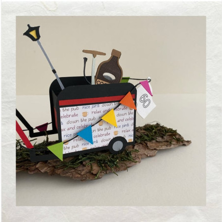 De aanhangwagen is met vlaggetjes versierd. Even als de cadeautjes uitgesneden met de Cricut uit papier.